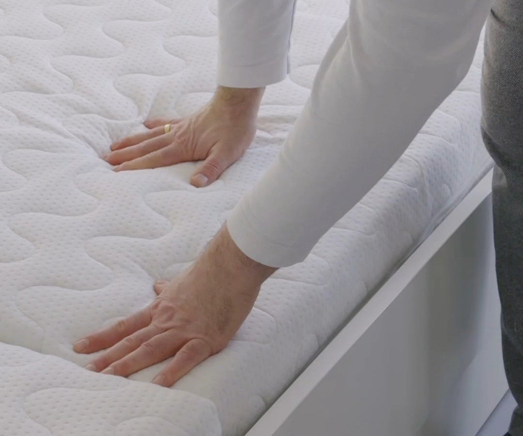Hände, die sich auf einer Matratze absttzen