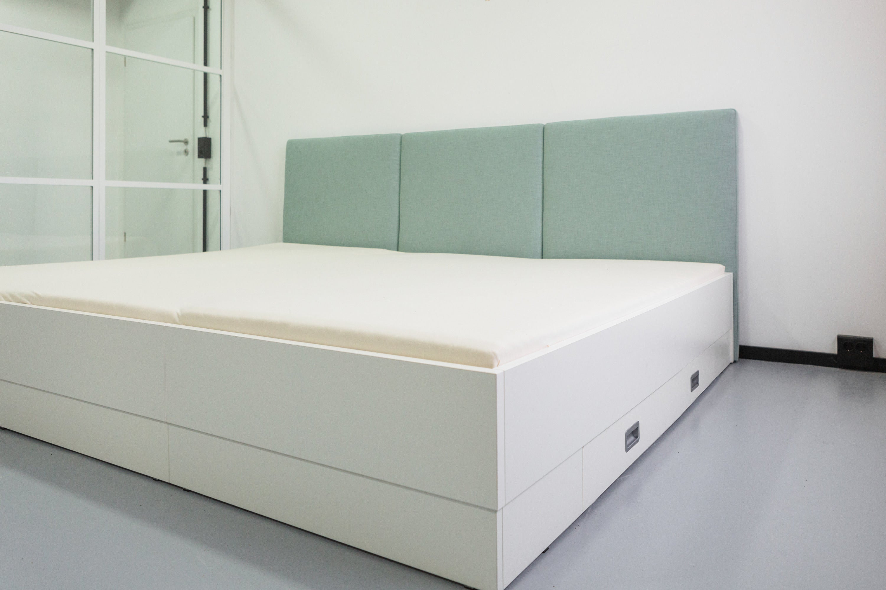 Familienbett Magnolia mit hellblauem Stoffkopfteil und Bettrahmen in weiß