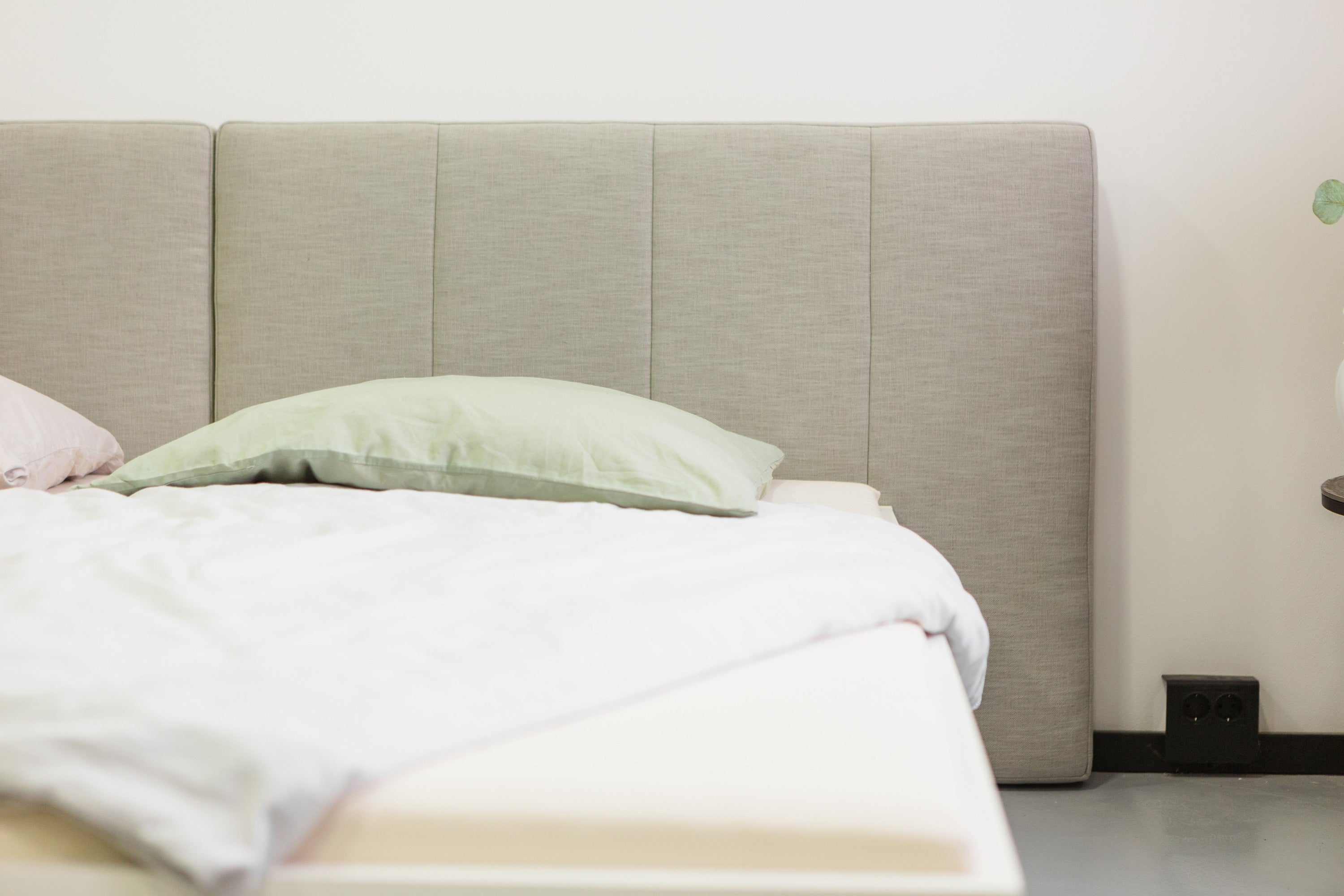 Hellgraues Kopfteil vom Polsterbett Lilia